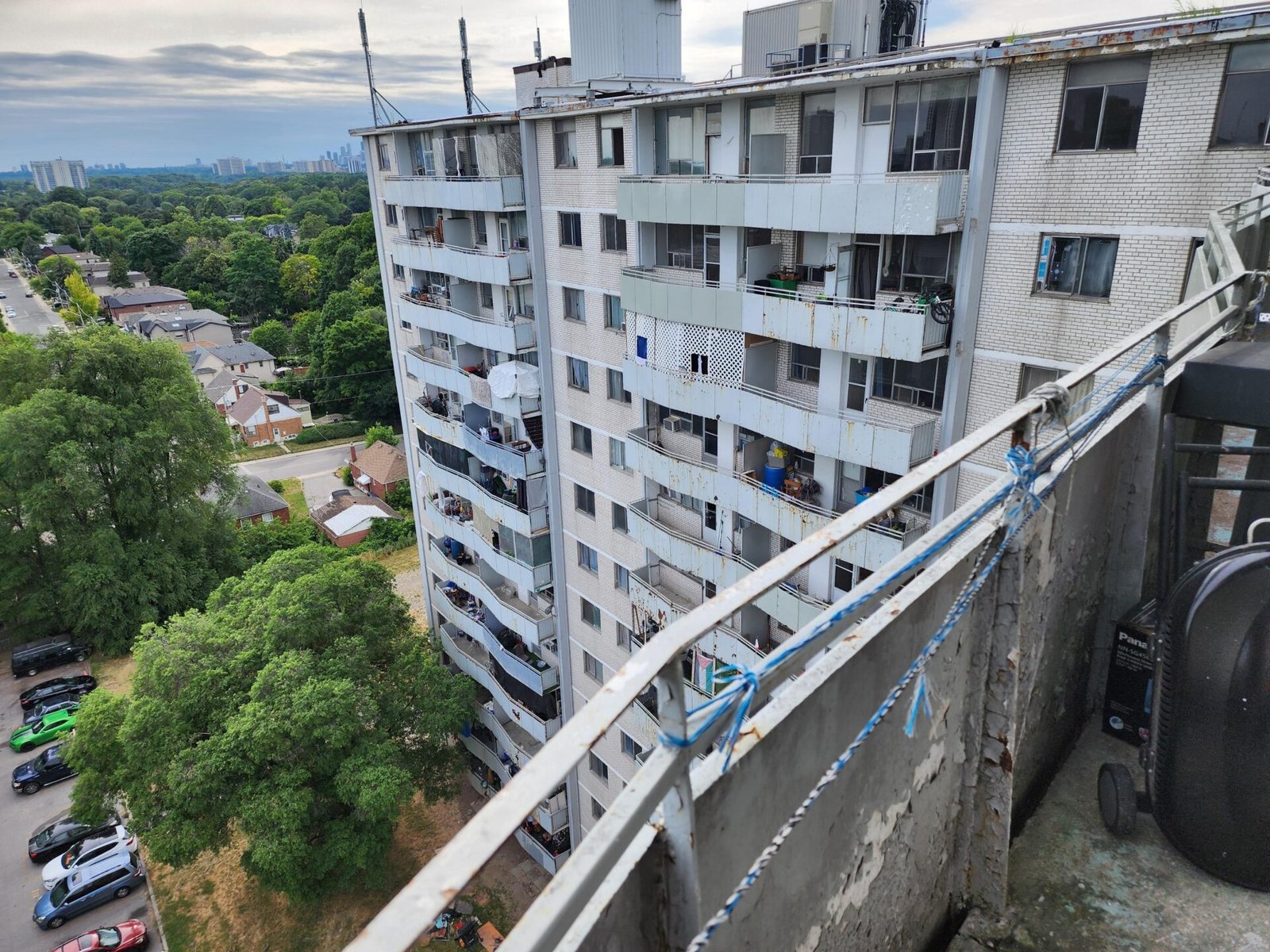 500 Dawes Road, Toronto — a 14-storey concrete apartment tower in Beaches-East York. View from a building balcony showing the tower's facade, balconies, and surrounding parkland.