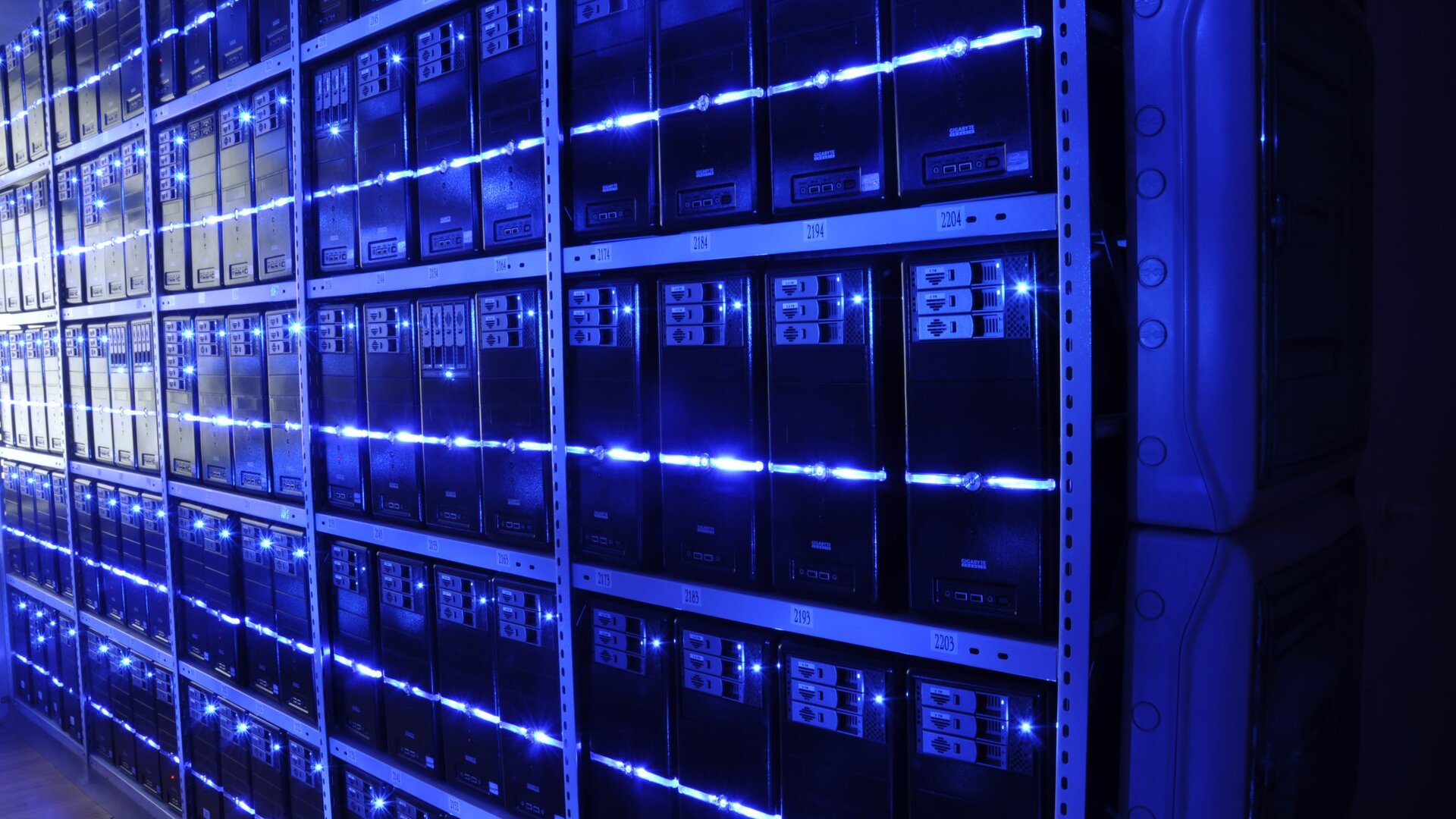 Rows of server racks lit by blue LED strips in a data centre