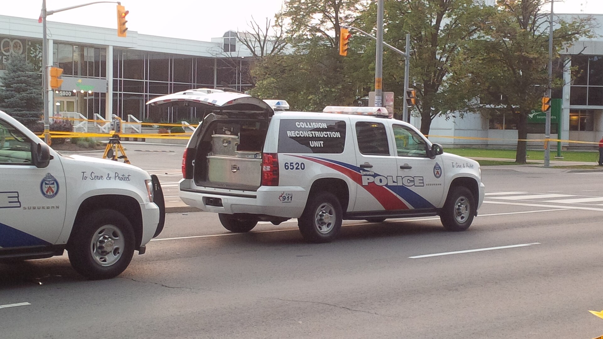 Two Toronto Police vehicles at a scene with crime-scene tape, including a Collision Reconstruction Unit.